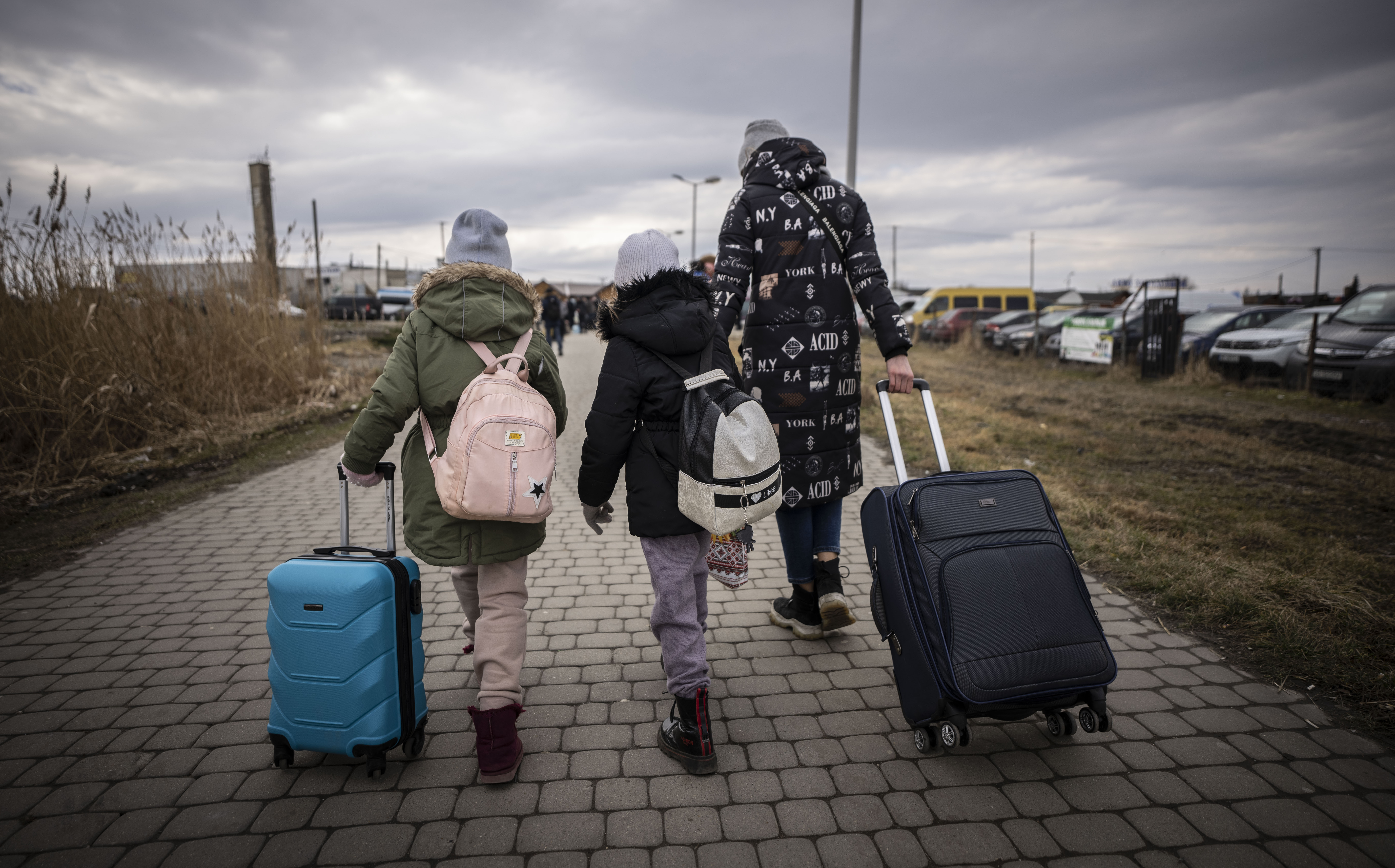 Enfants marchant de dos avec des valises