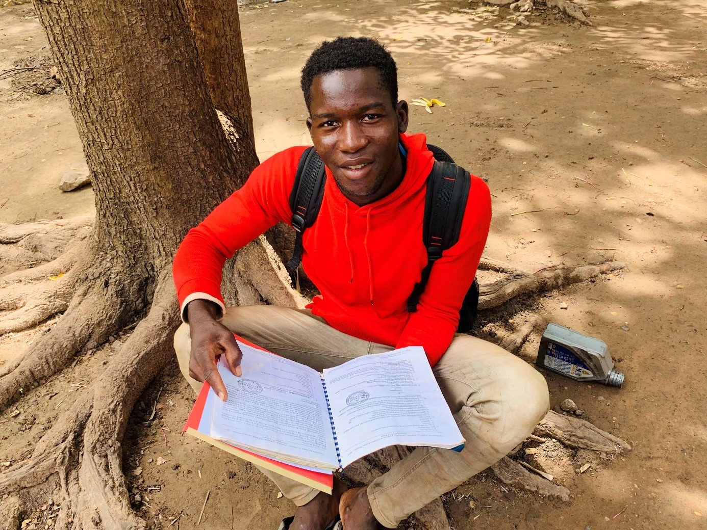 Jeune homme assit avec un cahier