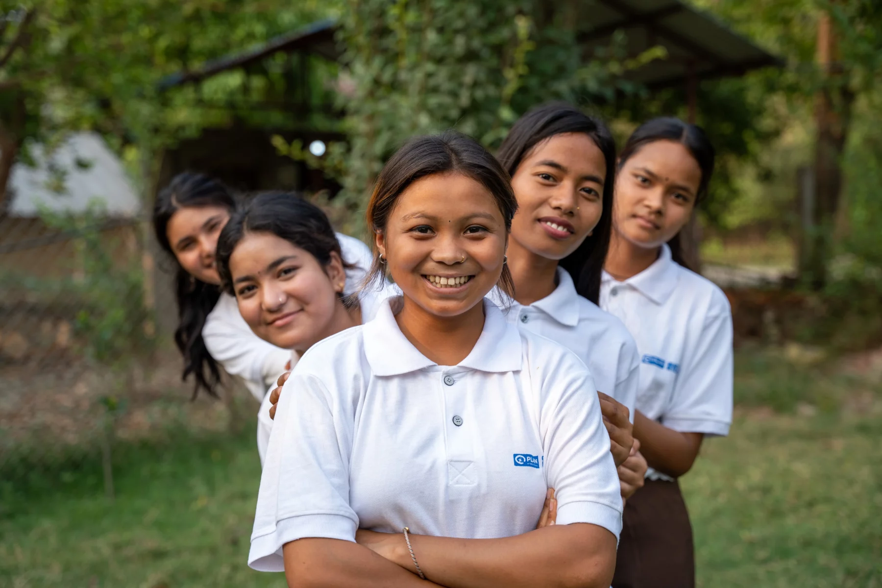 5 filles souriantes avec des polos Plan International