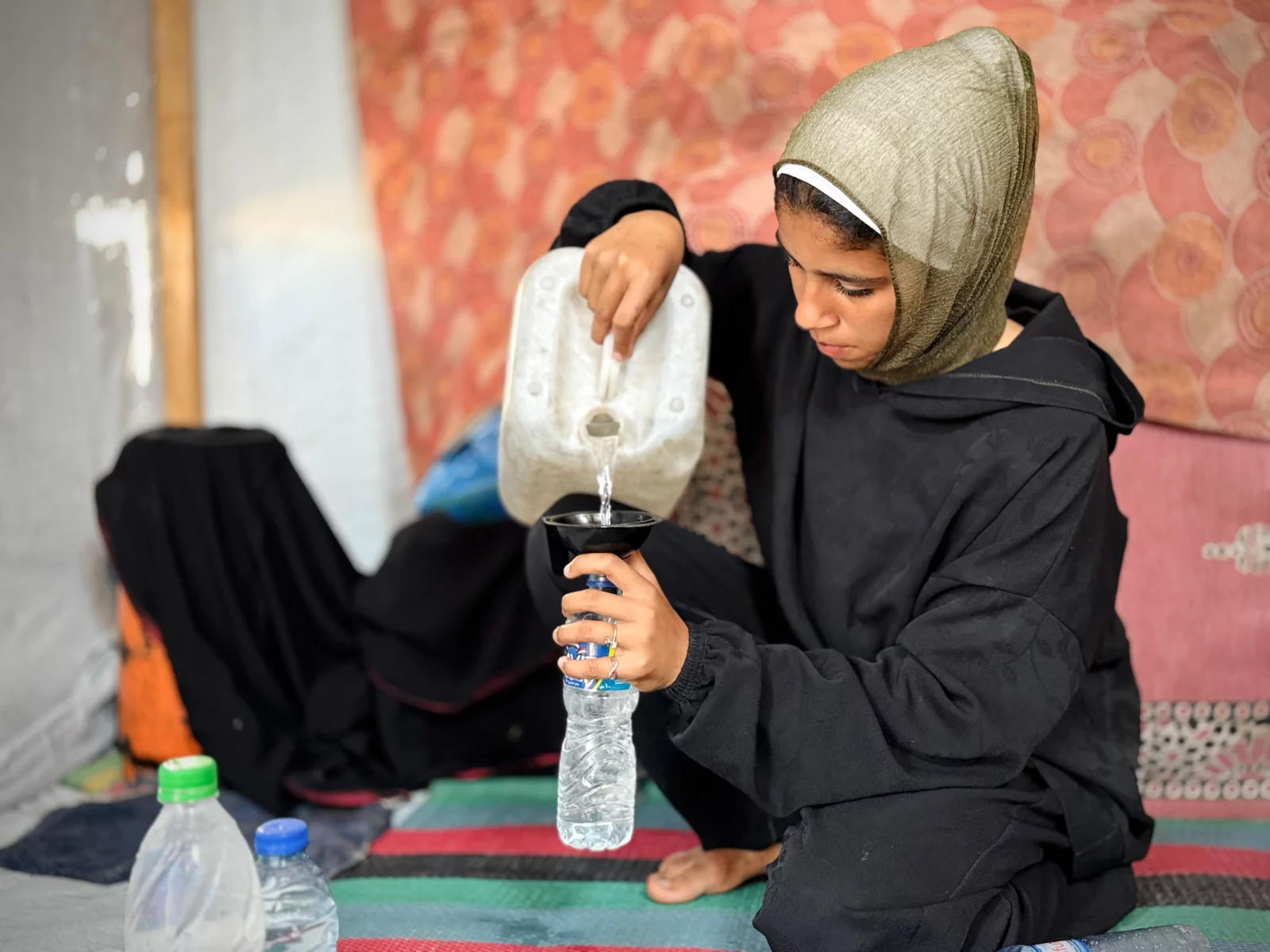 fille avec bidon remplissant une bouteille