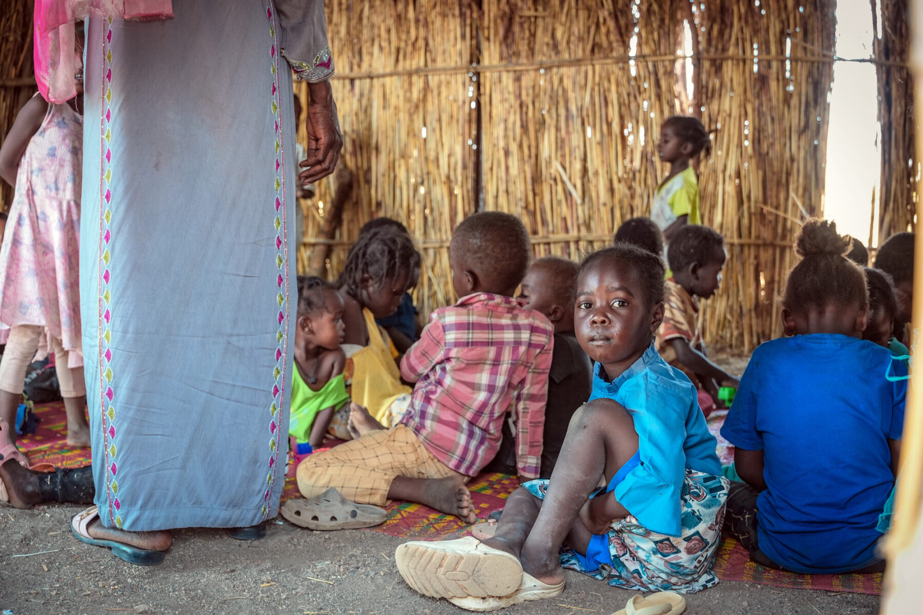 une petite fille assise entourée d'enfants