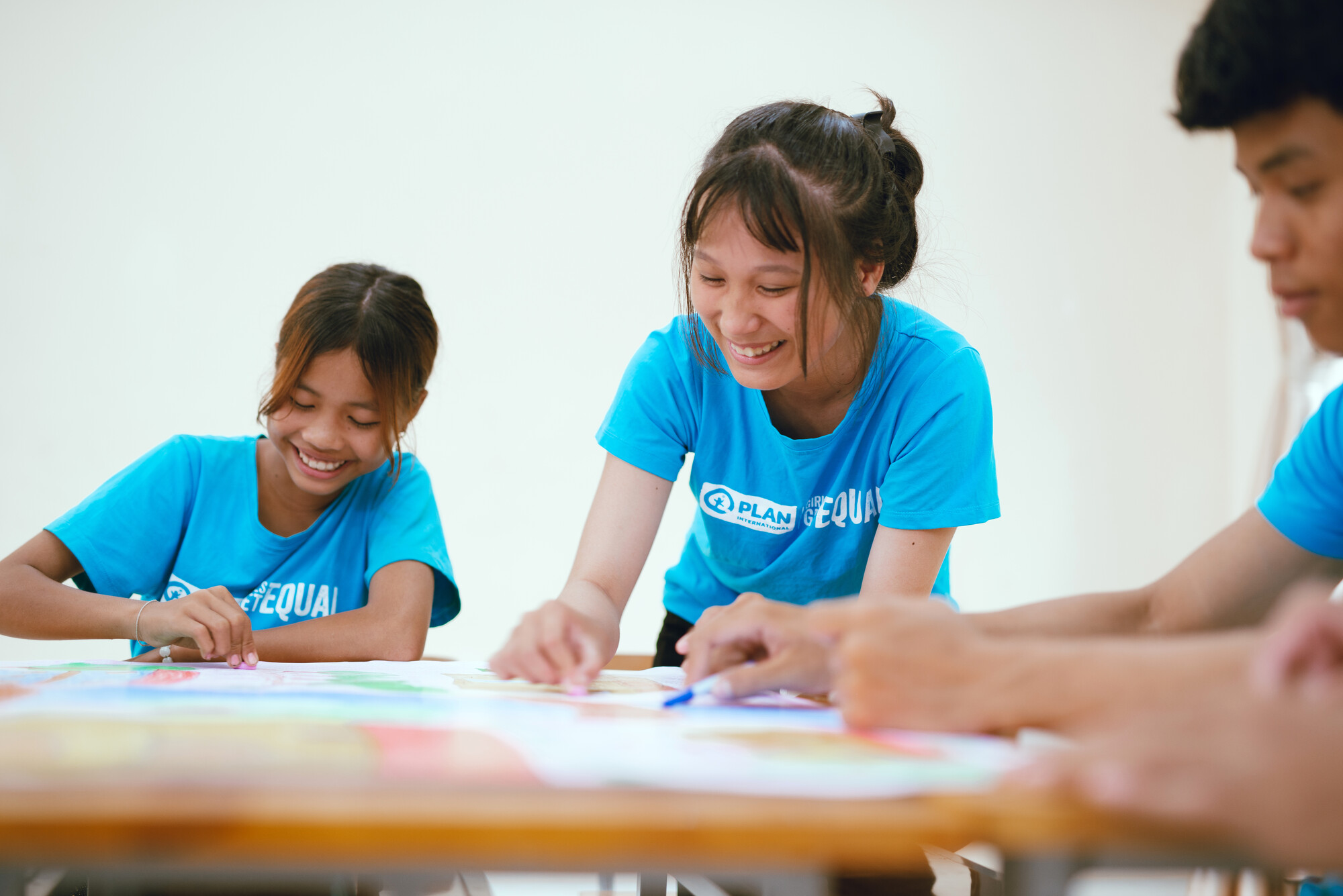 3 jeunes souriants travaillant sur un bureau